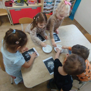 Dzieci wykonują pracę plastyczną "Płatek śniegu"