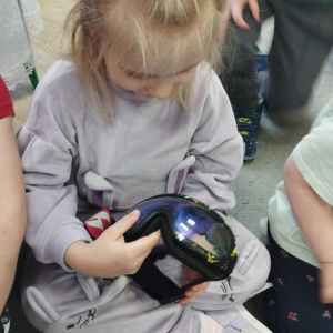 Dziewczynka ogląda gogle narciarskie.