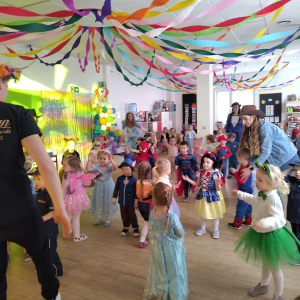 Dzieci tańczące podczas balu karnawałowego i naśladujące DJ.