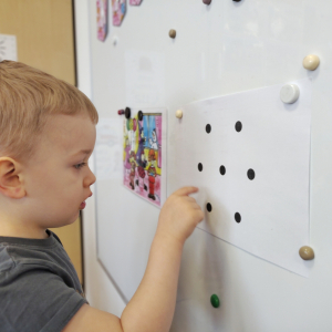 Chłopiec kreślący wzór przy tablicy