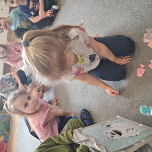 Dziecko wrzuca papierowe rybki ,karmi misia polarnego