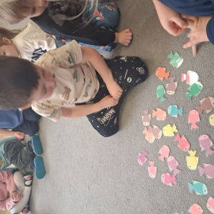 Dziecko wrzuca papierowe rybki ,karmi misia polarnego