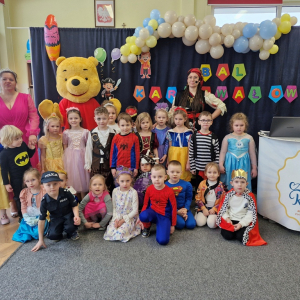 Dzieci, Pani Wioleta, Piratka i Kubuś Puchatek na tle dekoracji karnawałowej