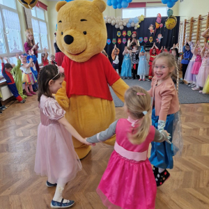 Dziewczynka tańczy z Kubusiem Puchatkiem