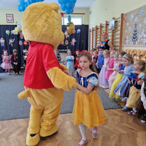 Dziewczynka tańczy z Kubusiem Puchatkiem