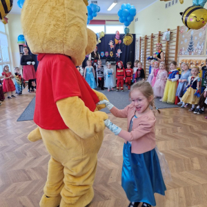 Dziewczynka tańczy z Kubusiem Puchatkiem