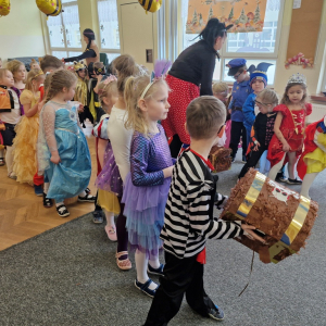 Dzieci przekazują dołem  skrzynkę ze skarbami 