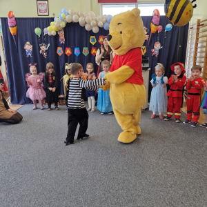 Chłopiec tańczy z Kubusiem Puchatkiem