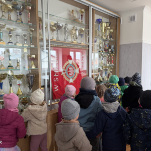 Podziwianie pucharów i nagród – przedszkolaki oglądają trofea zdobyte przez druhów za osiągnięcia i rywalizacje.
