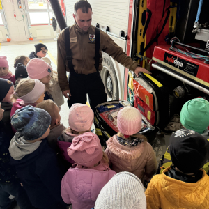 Pokaz sprzętu ratowniczego – druhowie Marek i Mateusz prezentują specjalistyczny sprzęt i pokazują, jak działa system alarmowy dla strażaków.