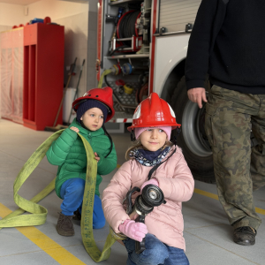 Zabawa edukacyjna z wężem strażackim - dzieci uczą się współpracy i koordynacji w zabawie z prawdziwym sprzętem. 