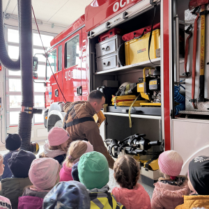 Pokaz sprzętu ratowniczego – druhowie Marek i Mateusz prezentują specjalistyczny sprzęt i pokazują, jak działa system alarmowy dla strażaków.
