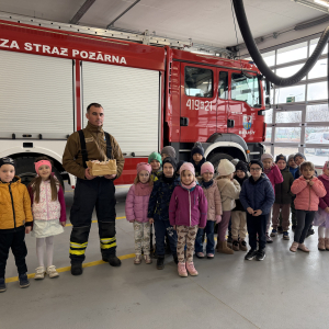  Pamiątkowe zdjęcie przedszkolaków z panem druhem i wozem strażackim na zakończenie wizyty.