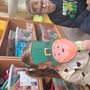 dziecko trzyma akcesoria do zdjeć z okazji Dnia Sw Patryka