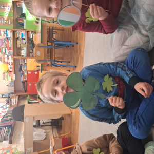 dziecko trzyma akcesoria do zdjeć z okazji Dnia Sw Patryka