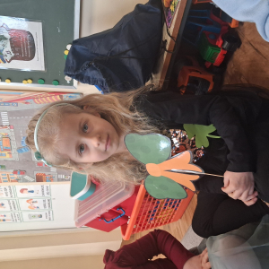 dziecko trzyma akcesoria do zdjeć z okazji Dnia Sw Patryka