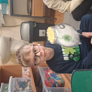 dziecko trzyma akcesoria do zdjeć z okazji Dnia Sw Patryka