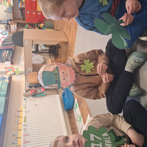 dziecko trzyma akcesoria do zdjeć z okazji Dnia Sw Patryka