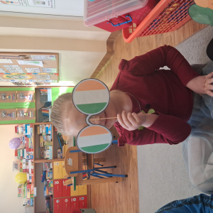 dziecko trzyma akcesoria do zdjeć z okazji Dnia Sw Patryka