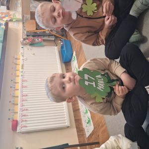 dziecko trzyma akcesoria do zdjeć z okazji Dnia Sw Patryka