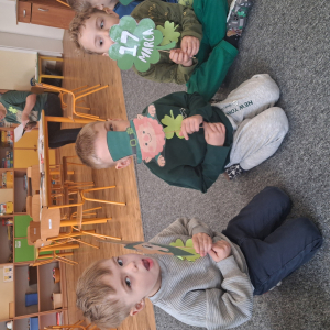 dzieci trzymają akcesoria do zdjęć o tematyce Dzień Św Patryka