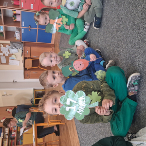 dzieci trzymają akcesoria do zdjęć o tematyce Dzień Św Patryka