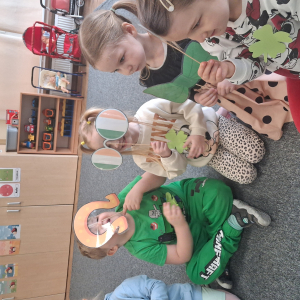 dzieci trzymają akcesoria do zdjęć o tematyce Dzień Św Patryka