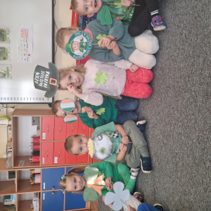 dzieci trzymają akcesoria do zdjęć o tematyce Dzień Św Patryka