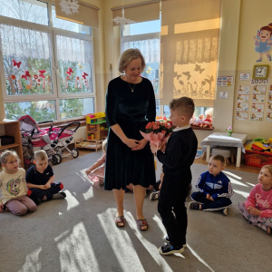 Chłopiec wręcza Pani Marysi kwiaty z okazji Dnia Kobiet