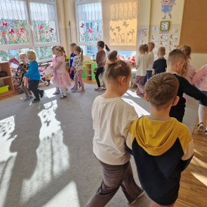 Dzieci maszerują w parach w rytm muzyki marszowej