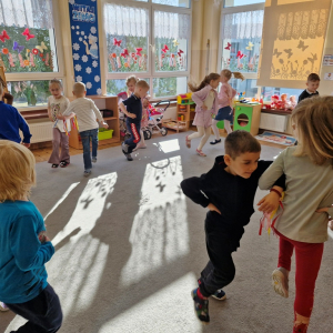 Dzieci  tańczą w parach naśladując wiatraczki