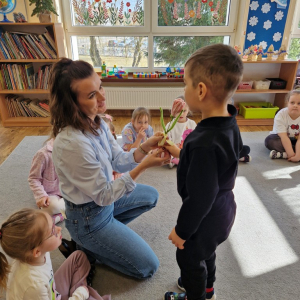 Chłopiec wręcza Pani Magdzie kwiaty z okazji Dnia Kobiet