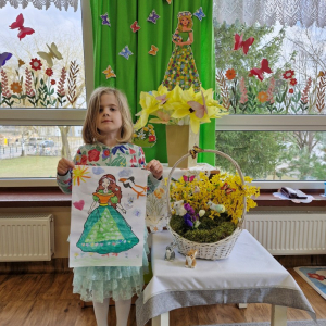 Dziewczynka prezentuje swoją pracę plastyczną "Pani Wiosna"