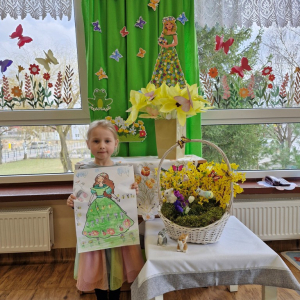 Dziewczynka prezentuje swoją pracę plastyczną "Pani Wiosna"