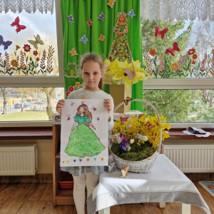 Dziewczynka prezentuje swoją pracę plastyczną "Pani Wiosna"