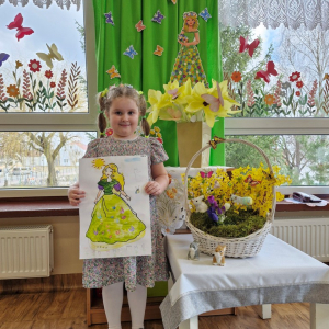 Dziewczynka prezentuje swoją pracę plastyczną "Pani Wiosna"