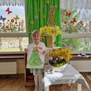 Dziewczynka prezentuje swoją pracę plastyczną "Pani Wiosna"