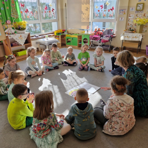 Pani Marysia wyjaśnia dzieciom sposób wykonania pracy plastycznej "Pani Wiosna" 