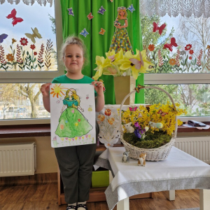 Dziewczynka prezentuje swoją pracę plastyczną "Pani Wiosna"