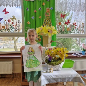 Dziewczynka prezentuje swoją pracę plastyczną "Pani Wiosna"