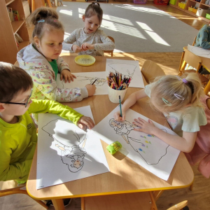 Dzieci kolorują i ozdabiają rysunkami wizerunek Pani Wiosny