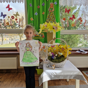 Dziewczynka prezentuje swoją pracę plastyczną "Pani Wiosna"