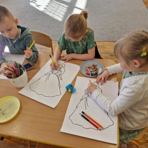 Dzieci kolorują i ozdabiają rysunkami wizerunek Pani Wiosny