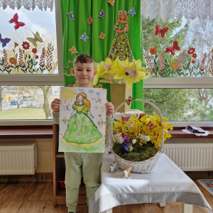 Chłopiec prezentuje swoją pracę plastyczną "Pani Wiosna"