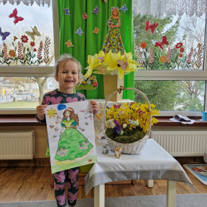 Dziewczynka prezentuje swoją pracę plastyczną "Pani Wiosna"