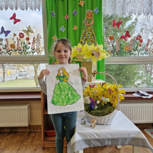 Dziewczynka prezentuje swoją pracę plastyczną "Pani Wiosna"