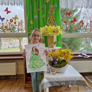 Dziewczynka prezentuje swoją pracę plastyczną "Pani Wiosna"