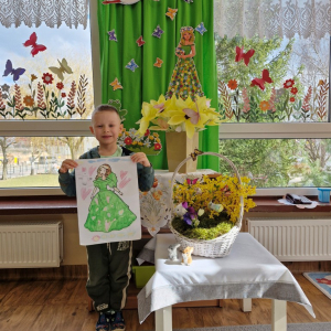 Chłopiec prezentuje swoją pracę plastyczną "Pani Wiosna"