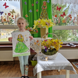 Dziewczynka prezentuje swoją pracę plastyczną "Pani Wiosna"