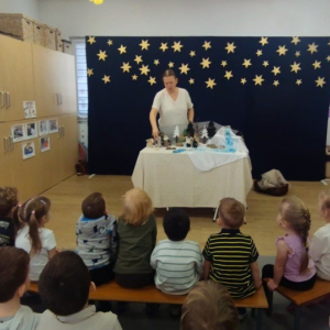 Dzieci z zaciekawieniem oglądają teatrzyk z koszyka.